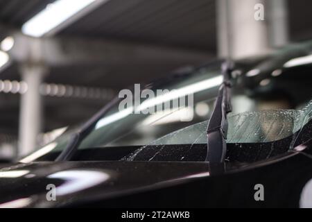 Photo recadrée d'un pare-brise mouillé lors d'un lavage de voiture. Concept de lave-auto. Gros plan du style moderne d'essuie-glace de voiture Banque D'Images