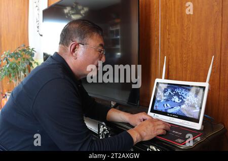 (231018) -- ORDOS, 18 octobre 2023 (Xinhua) -- Dorji vérifie ses chèvres à l'intérieur de sa maison grâce à un moniteur à Otog Banner d'Ordos, dans la région autonome de Mongolie intérieure du nord de la Chine, le 16 octobre 2023. Dorji est un berger de 61 ans vivant à Otog Banner. Pendant la saison d'automne, la routine quotidienne de Dorji comprend l'élevage de chevaux et de chèvres. Il possède plus de 200 chèvres en cachemire Arabas, qui offrent des rendements économiques sains. Dans ses temps libres, Dorji participe à une activité culturelle locale appelée « Nair » avec son père de 91 ans, Mingan-erdeni. 'Nair' remonte à la dynastie Yuan (1271-1368) et est un for Banque D'Images