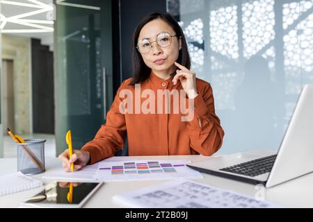 Portrait d'une femme d'affaires asiatique sérieuse et confiante financier dans le bureau au travail, travailleur derrière la paperasse regardant pensivement à la caméra, Worki Banque D'Images