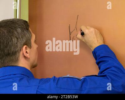 Le cosmonaute Nikolai Chub de Roscosmos signe une fresque murale à l'hôtel Cosmonaut à Baïkonour, Kazakhstan, le 15 septembre 2023, avant de partir avec l'astronaute de la NASA Loral O'Hara et le cosmonaute Oleg Kononenko pour leur lancement Soyouz vers la Station spatiale internationale pour l'expédition 70. Banque D'Images