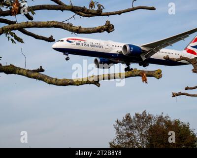 Aéroport de Londres Heathrow Hounslow British Airways Ba avion volant à basse altitude devant des arbres, quelques secondes avant d'atterrir à l'aéroport de Heathrow Banque D'Images