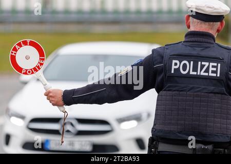 Furth im Wald, Allemagne. 18 octobre 2023. Un agent de la police fédérale arrête le conducteur d'une voiture entrant dans le pays au poste frontalier germano-tchèque Furth im Wald - Ceska Kubice. Crédit : Daniel Karmann/dpa/Alamy Live News Banque D'Images