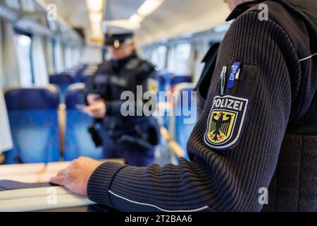 Furth im Wald, Allemagne. 18 octobre 2023. Des agents de la police fédérale vérifient les papiers d'un passager lors d'un contrôle de l'immigration dans un train en provenance de Prague en direction de Munich. Crédit : Daniel Karmann/dpa/Alamy Live News Banque D'Images