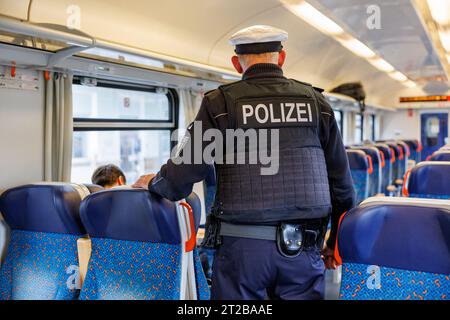 Furth im Wald, Allemagne. 18 octobre 2023. Des agents de la police fédérale vérifient les papiers d'un passager lors d'un contrôle de l'immigration dans un train en provenance de Prague en direction de Munich. Crédit : Daniel Karmann/dpa/Alamy Live News Banque D'Images