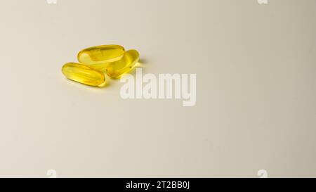 Capsules de saumon sauvage et d'huile de poisson riches en oméga-3 présentées sur un fond blanc cassé doux. Banque D'Images