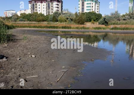 Lac sec, sol fissuré sec. Les vestiges, la dernière goutte d'eau, d'un lac marécageux presque sec dans un parc de la ville. Problèmes environnementaux, réchauffement climatique, l Banque D'Images