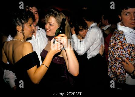 Les jeunes femmes des années 1980 ont bondé la piste de danse une bouteille de vin. Dîner dansant au Tysoe Manor, Tysoe, Warwickshire, Angleterre avril 1982. ROYAUME-UNI HOMER SYKES Banque D'Images