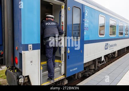 Furth im Wald, Allemagne. 18 octobre 2023. Les policiers fédéraux montent à bord d'un train en provenance de Prague en direction de Munich pour vérifier le trafic d'entrée. À la suite de la concession du ministre fédéral de l'intérieur, la police fédérale a commencé à effectuer des contrôles stationnaires à la frontière entre la Bavière et la République tchèque. Crédit : Daniel Karmann/dpa/Alamy Live News Banque D'Images