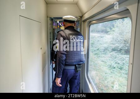 Furth im Wald, Allemagne. 18 octobre 2023. Des agents de la police fédérale contrôlent le trafic d'entrée à bord d'un train en provenance de Prague en direction de Munich. À la suite de la concession du Ministre fédéral de l'intérieur, la police fédérale a entamé des contrôles stationnaires à la frontière entre la Bavière et la République tchèque. Crédit : Daniel Karmann/dpa/Alamy Live News Banque D'Images