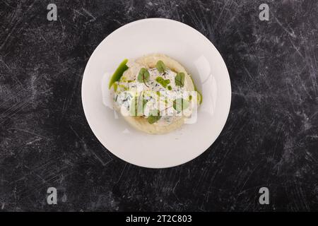 Une portion de galettes de bœuf russes avec purée de pommes de terre et herbes sur un fond sombre Banque D'Images