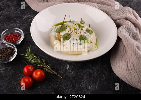 Une portion de galettes de bœuf russes avec purée de pommes de terre et herbes sur un fond sombre Banque D'Images