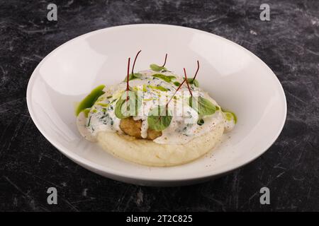 Une portion de galettes de bœuf russes avec purée de pommes de terre et herbes sur un fond sombre Banque D'Images