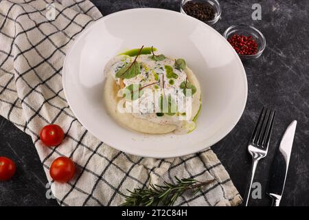 Une portion de galettes de bœuf russes avec purée de pommes de terre et herbes sur un fond sombre Banque D'Images