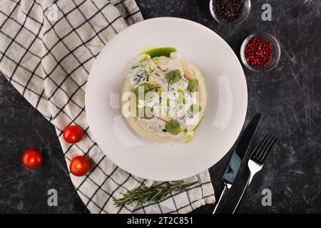 Une portion de galettes de bœuf russes avec purée de pommes de terre et herbes sur un fond sombre Banque D'Images