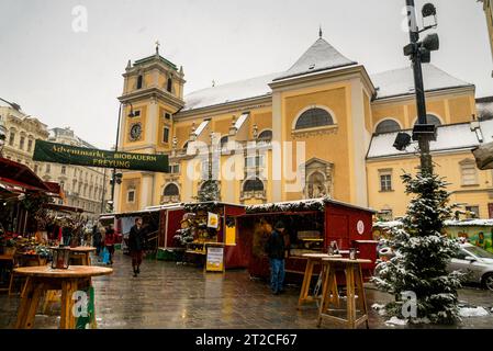 Monastère Schottenstift à Vienne, Autriche et le marché de Noël Freyung et place dans la neige. Banque D'Images