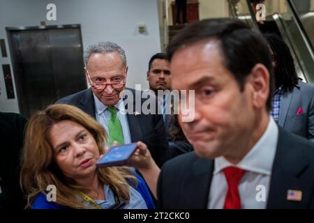 Le leader de la majorité au Sénat des États-Unis Chuck Schumer (démocrate de New York) écoute tandis que le sénateur américain Marco Rubio (républicain de Floride) fait des remarques aux journalistes suite à une réunion de tous les sénateurs au Capitole des États-Unis à Washington, DC, mercredi 18 octobre 2023. Crédit : Rod Lamkey/CNP Banque D'Images