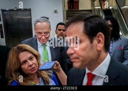 Le leader de la majorité au Sénat des États-Unis Chuck Schumer (démocrate de New York) écoute tandis que le sénateur américain Marco Rubio (républicain de Floride) fait des remarques aux journalistes suite à une réunion de tous les sénateurs au Capitole des États-Unis à Washington, DC, mercredi 18 octobre 2023. Crédit : Rod Lamkey/CNP Banque D'Images
