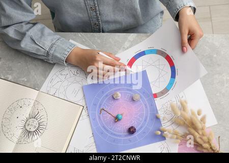 Astrologue utilisant la roue du zodiaque pour la prévision de destin à la table, vue de dessus. Dire la fortune Banque D'Images