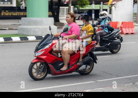 SAMUT PRAKAN, THAÏLANDE, octobre 11 2023, Une femme roule avec un garçon sur une moto. Banque D'Images