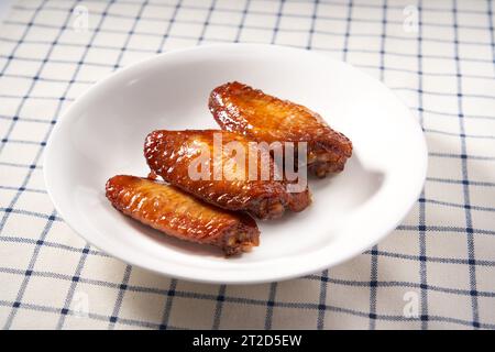 Une assiette d'ailes de poulet grillées dorées et alléchantes au miel Banque D'Images