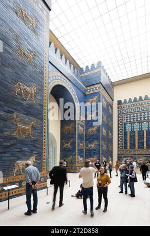 PRODUCTION - 17 octobre 2023, Berlin : les visiteurs se tiennent devant la porte Ishtar de Babylone dans le musée de Pergame. À partir d’octobre 23, les portes seront complètement fermées pendant quelques années, les rénovations devraient prendre 14 ans. Photo : Sebastian Christoph Gollnow/dpa Banque D'Images