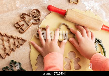 Mains des enfants avec des biscuits en pain d'épice sur fond en bois, vue de dessus Banque D'Images