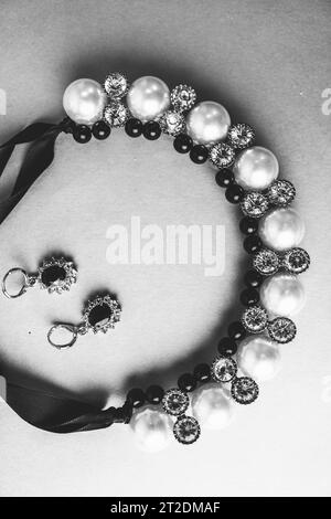 Beau précieux bijoux brillants précieux bijoux glamour à la mode, collier et boucles d'oreilles avec des perles et des diamants, diamants sur un noir et blanc Banque D'Images
