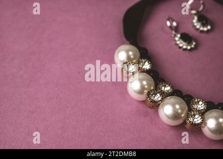 Beau cher précieux bijoux brillants bijoux tendance glamour bijoux, collier et boucles d'oreilles avec perles et diamants, diamants sur un rose violet ba Banque D'Images