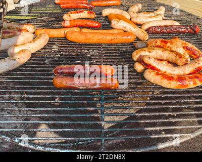 plats grillés. saucisses juteuses et copieuses sur le gril pour la cuisson de la viande et des steaks. plat de viande appétissant. festival culinaire dans le parc de la ville. Banque D'Images