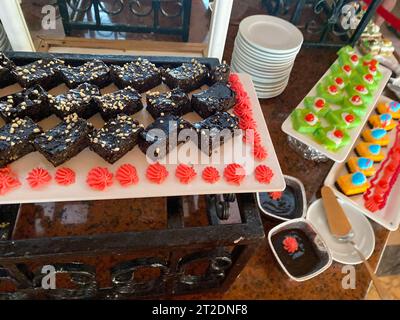 Assortiment de desserts à base de bonbons au chocolat dans une vitrine de cafés. Variété de bonbons aux saveurs différentes noix en magasin. Banque D'Images