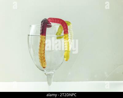 Brillant savoureux beau juteux multicolore gélatineux bonbons sucrés gommeux se trouvent dans un verre à vin en verre transparent. Cocktail de desserts sucrés. Banque D'Images