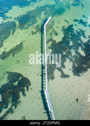 Vue aérienne d'une longue jetée étroite au-dessus d'une baie côtière peu profonde avec des récifs rocheux à Queenscliff sur la péninsule de Bellarine dans le Victoria, Australie Banque D'Images