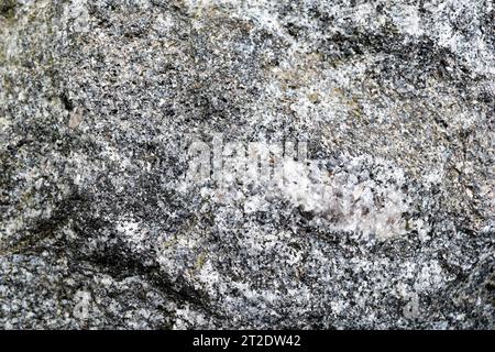 Texture de vieille pierre dure gris-blanc avec des fissures, des bosses et des motifs, fond. Banque D'Images