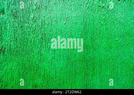 Texture en relief saturé vert vif magnifiquement peinte avec de la peinture en bois avec des rayures verticales, des fissures, un beau motif, un arrière-plan. Banque D'Images