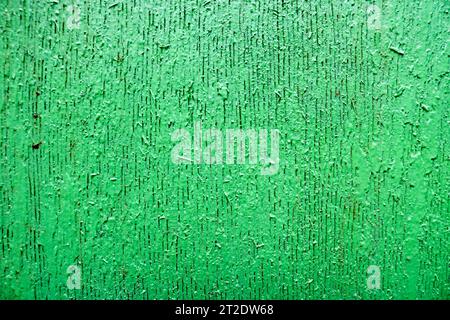 Texture en relief saturé vert vif de bois magnifiquement peint avec des rayures verticales, des fissures, un arrière-plan. Banque D'Images