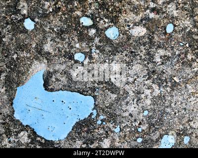 La texture de l'ancien mur de plâtre cimenté en béton gris avec des fissures trous dentelés dans les motifs et les divorces, morceaux d'éclats et peinture bleue de pelage, Banque D'Images