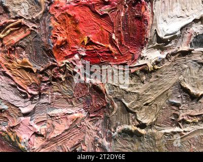 texture lumineuse et multicolore avec une tache rouge au centre. peinture acrylique sur toile. palette, taches de peinture mélangées avec de l'eau. la texture est hétérog Banque D'Images