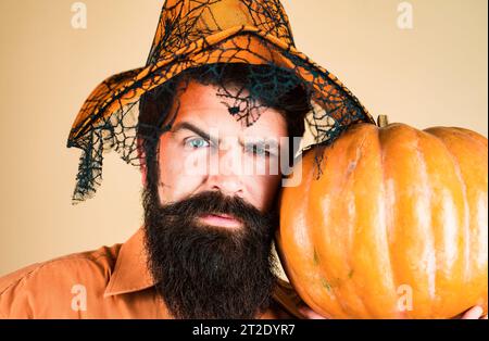 Autocollants Happy Halloween. Sourire heureux homme avec citrouille. Halloween Homme posant avec des citrouilles. Ingrédients de cuisine de saison de Thanksgiving. Banque D'Images