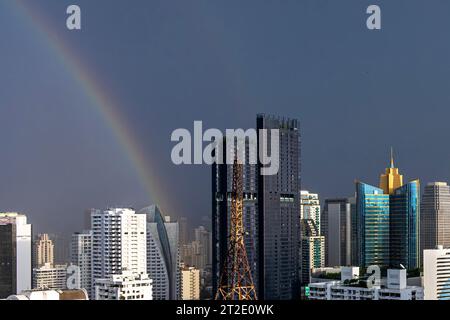Arc-en-ciel, pluie, soleil et nuages de tempête au-dessus de Bangkok gratte-ciel, région de Sukhumvit, Thaïlande Banque D'Images