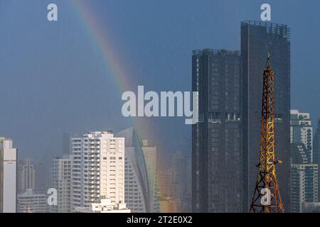 Arc-en-ciel, pluie, soleil et nuages de tempête au-dessus de Bangkok gratte-ciel, région de Sukhumvit, Thaïlande Banque D'Images