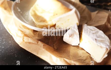 Camembert et crêpe sur papier parchemin et planche de bois Banque D'Images