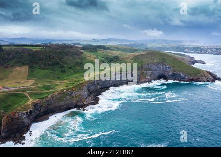 Vue aérienne d'un paysage côtier avec falaises rocheuses et prairies verdoyantes. Cantabrie, Espagne. Banque D'Images