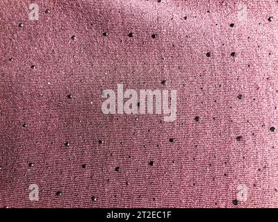Texture de tissu synthétique violet rose avec de belles pierres précieuses noires argentées, diamants. L'arrière-plan. Banque D'Images