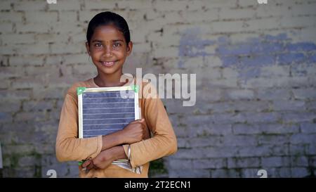 Portrait de la petite fille indienne mignonne heureuse à l'école tenant l'ardoise vierge, adorable enfant élémentaire montrant le tableau noir. concept d'éducation de l'enfant. rural i Banque D'Images