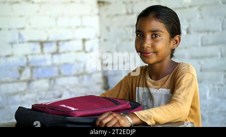 Garçon d'école rurale indienne souriante avec sac à dos regardant la caméra. Enfant joyeux portant l'uniforme scolaire avec un grand sourire. École primaire et primaire e Banque D'Images