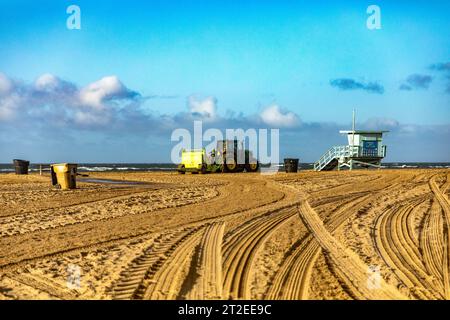 Tracteur labourant le sable fin blanc de la plage dans la ville de Santa Monica dans l'état de Californie aux États-Unis d'Amérique, sous un beaut Banque D'Images