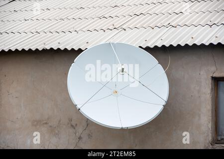 Antenne TV satellite sur le mur de la maison. Récepteur d'antenne rond blanc pour signal radio. Antenne de ville pour télévision, radio, Internet. Banque D'Images