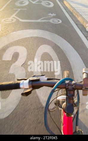 Cycliste roulant y voie prioritaire pour les vélos et les scooters électriques de coup de pied. POV shot Banque D'Images