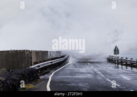 Orkney, Royaume-Uni. 19 octobre 2023. MÉTÉO au Royaume-Uni : la tempête Babet frappe les Orcades avec des vents violents alors que le met Office émet un avertissement météorologique jaune pour le nord-est de l'Écosse. Les vents violents provoquent l'écrasement des vagues sur l'A961 qui traverse l'une des barrières Churchill sur les îles. Crédit : Peter Lopeman/Alamy Live News Banque D'Images