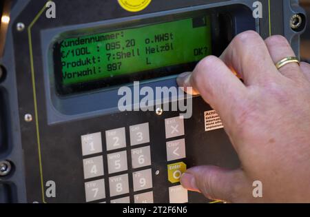 Bad Brahmstedt, Allemagne. 18 octobre 2023. Un employé d'une entreprise de diesel et de mazout vérifie le relevé du compteur pour la livraison de mazout à un client dans une maison unifamiliale. Crédit : Christian Charisius/dpa/Alamy Live News Banque D'Images